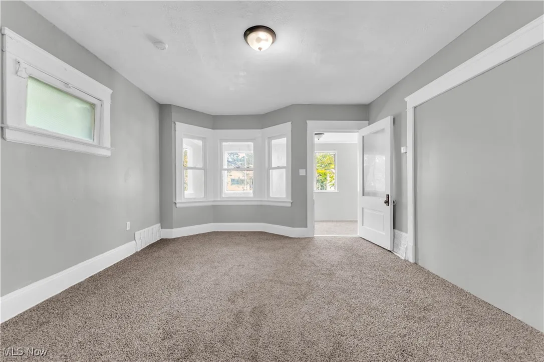 Carpeted empty room featuring baseboards