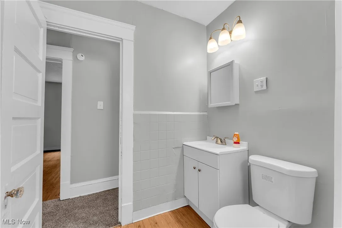 Half bathroom featuring vanity and wood finished floors