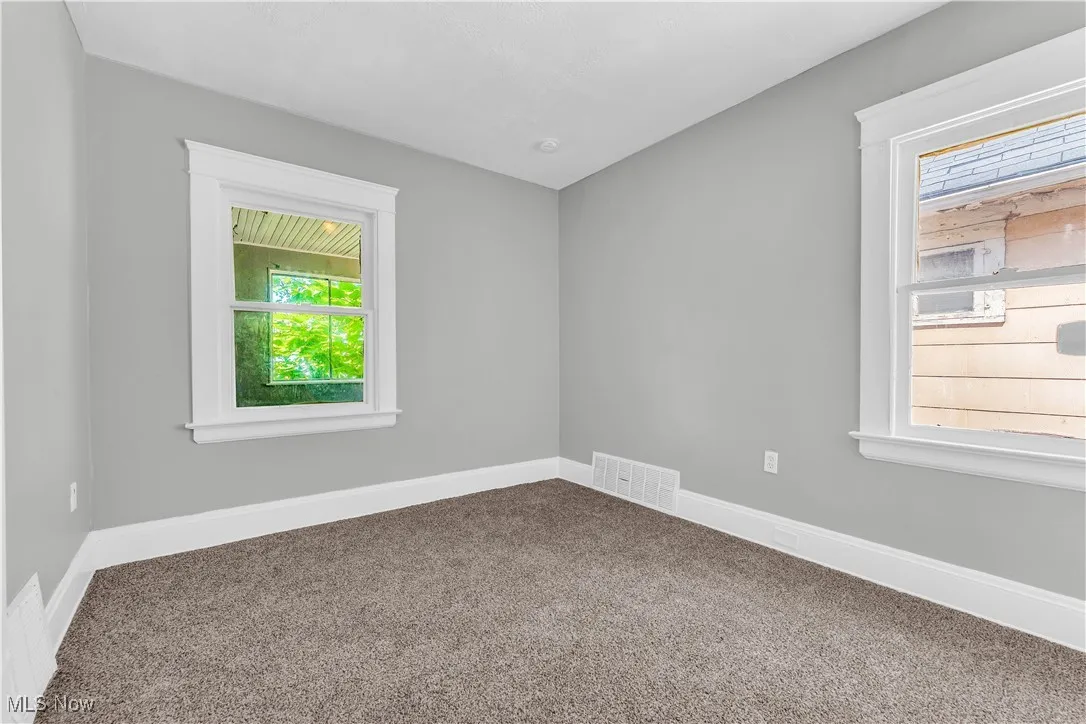 Carpeted empty room featuring baseboards