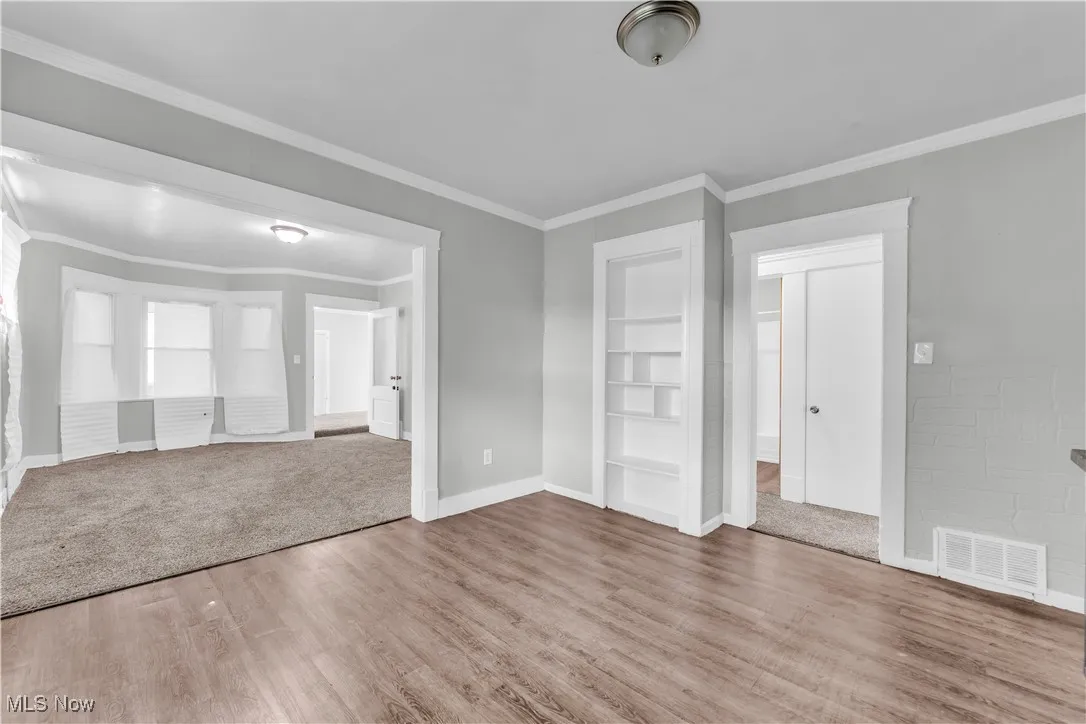 Empty room with wood finished floors and crown molding