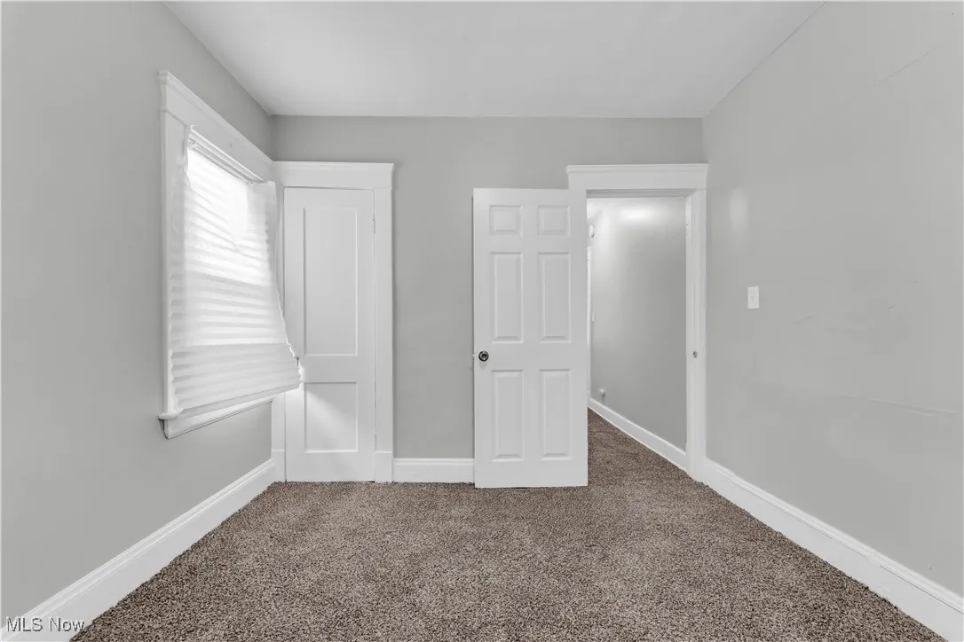Unfurnished bedroom with carpet floors and baseboards