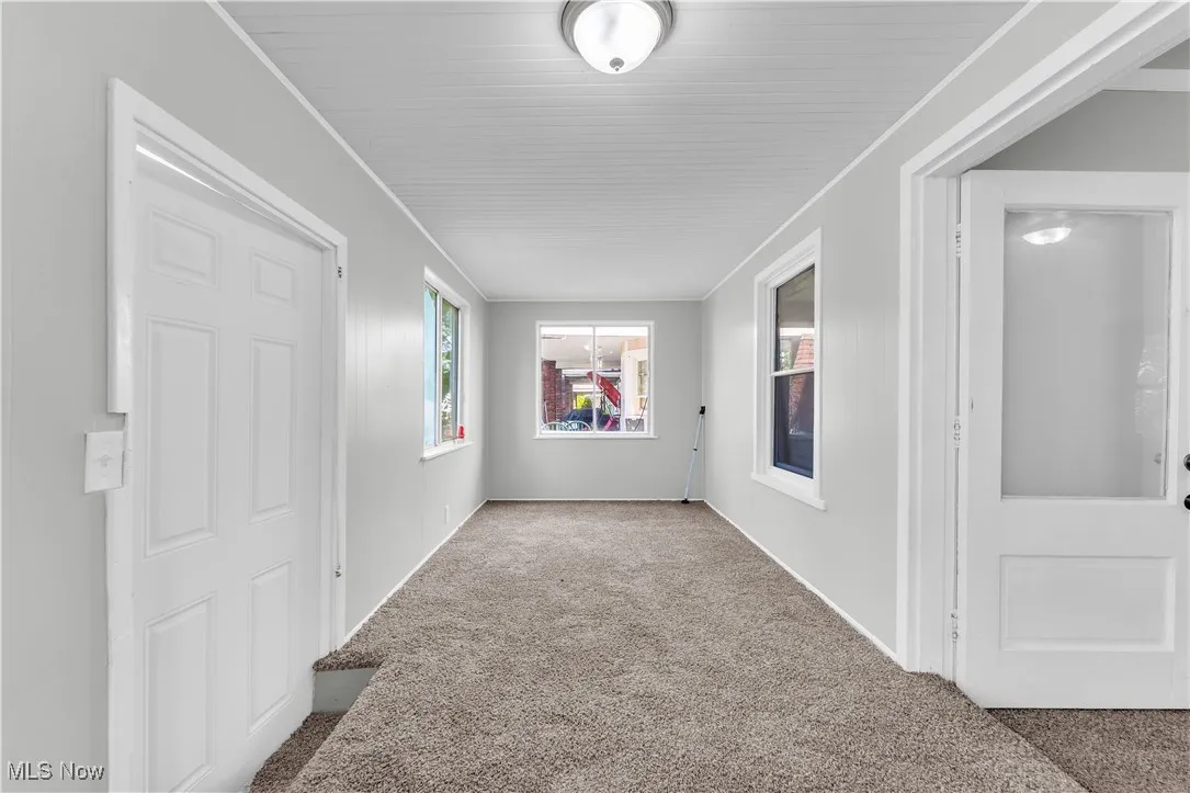 Unfurnished room featuring carpet flooring and crown molding