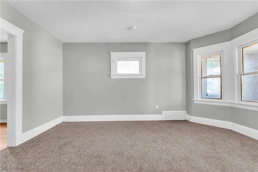 Carpeted spare room with healthy amount of natural light