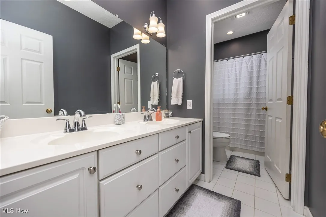 Bathroom featuring tile floors and double vanity