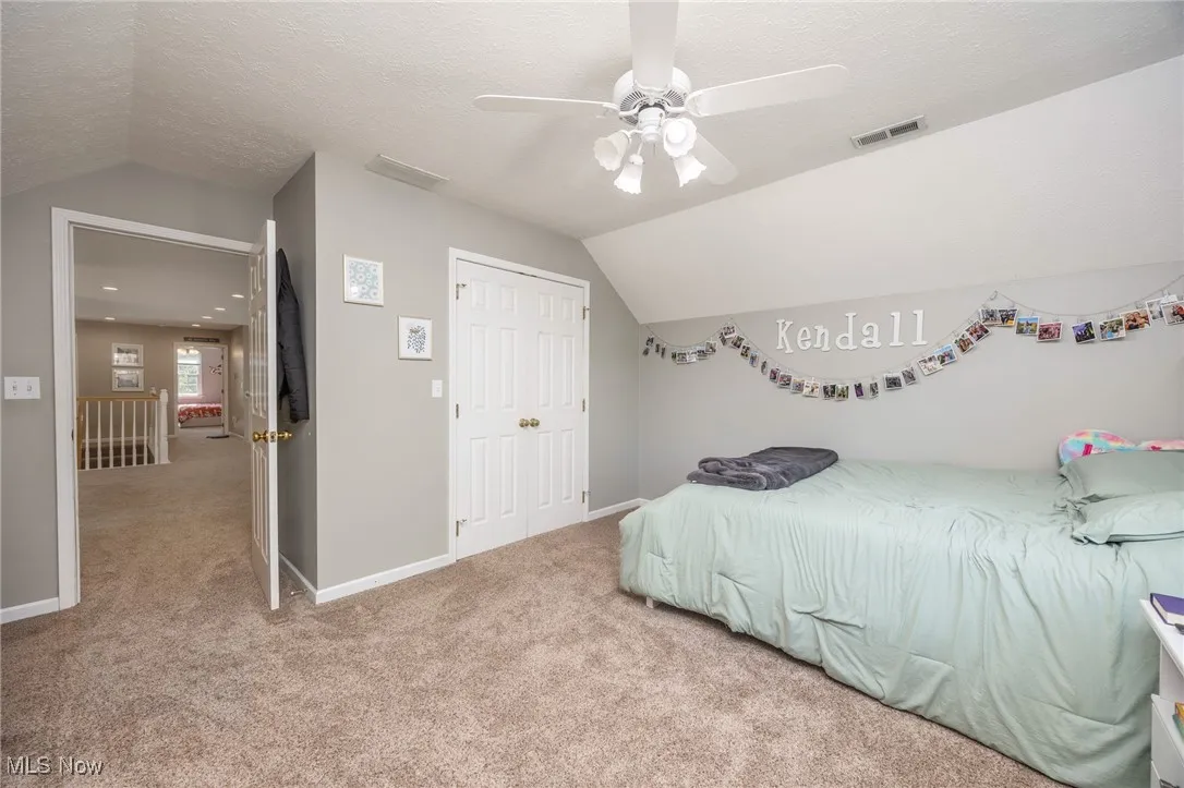 Bedroom featuring carpet flooring, lofted ceiling, a closet, and ceiling fan