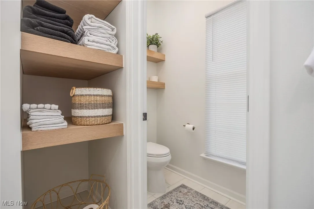 Primary bathroom with toilet room and tile patterned flooring