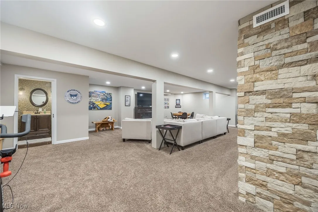 Lower-level living area with carpet and recessed lighting
