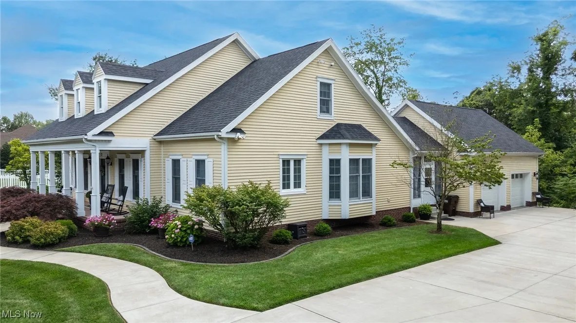 View of front of home featuring a shingled roof, a front lawn, concrete driveway, a garage, and a porch