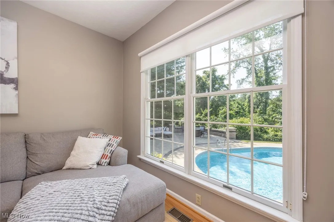 Family room area with healthy amount of natural light and hardwood floors with view of pool area
