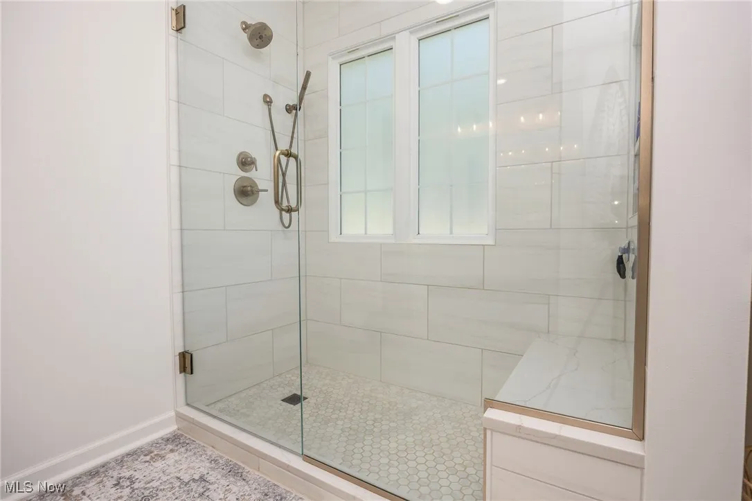 Primary bathroom featuring a tiled walk-in shower.