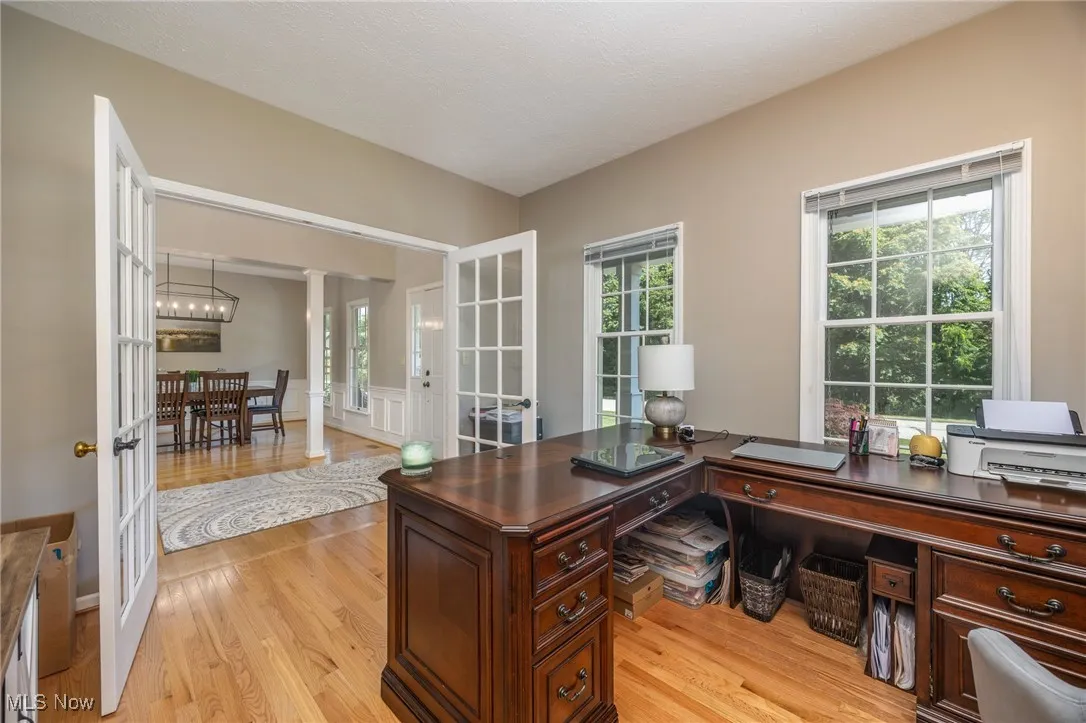Home office featuring light hardwood flooring, French doors and ample light.