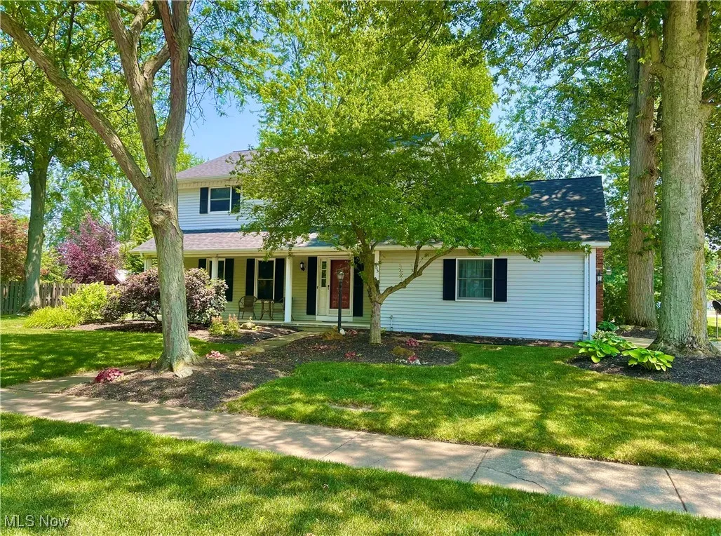 View of front this 3 BR Colonial home with large covered porch, and wonderful mature trees providing lots of shade