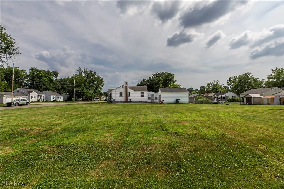 View of green lawn with a residential view