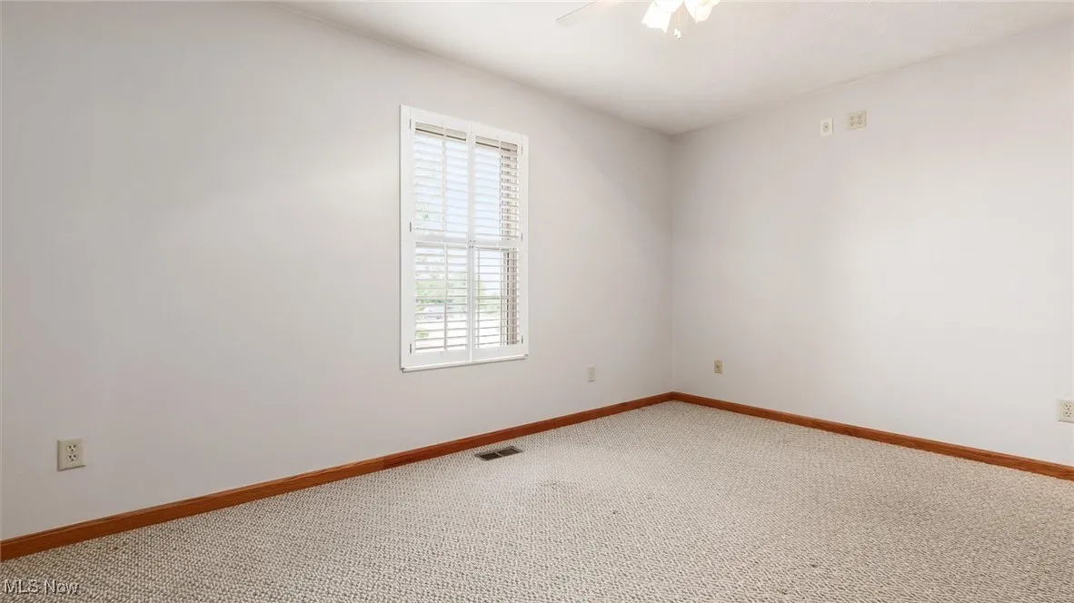 Unfurnished room with light carpet and a ceiling fan