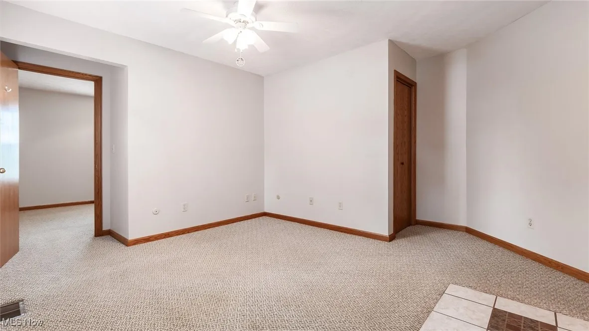 Spare room with ceiling fan and light colored carpet