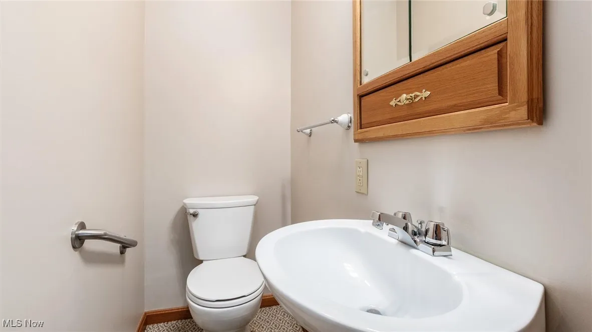 Half bath featuring toilet and a sink