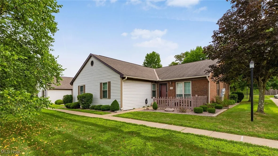 Ranch-style house featuring a front yard, roof with shingles, and brick siding