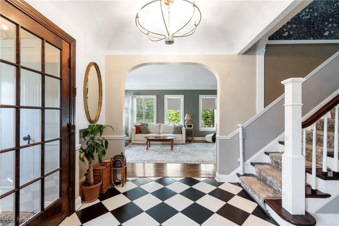 Foyer entrance featuring arched walkways, tile patterned floors, and stairs