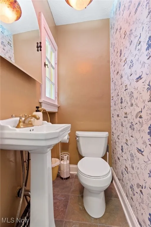 Bathroom featuring toilet and curtained shower
