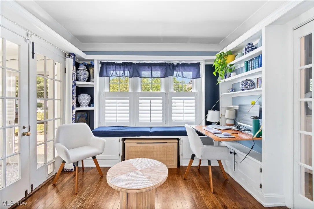 Office area featuring built in study area, french doors, wood finished floors, crown molding, and radiator heating unit