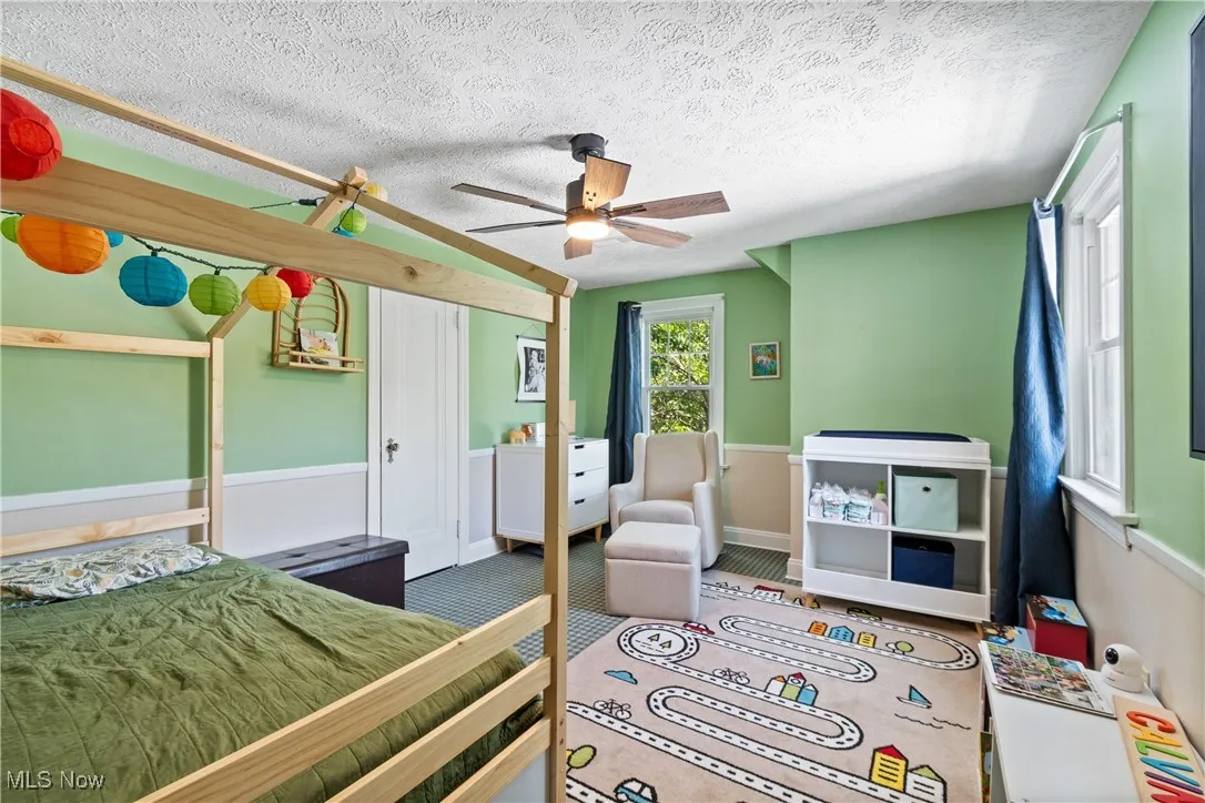 Bedroom with a textured ceiling, ceiling fan, and a closet