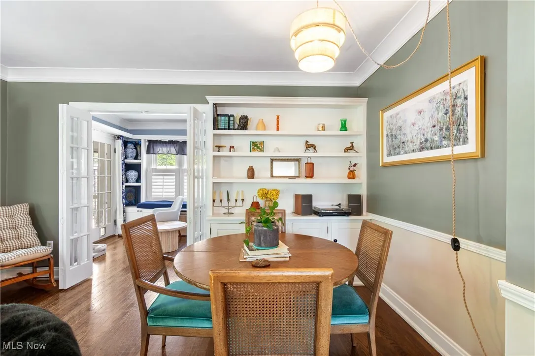 Dining room featuring dark wood-type flooring and crown molding