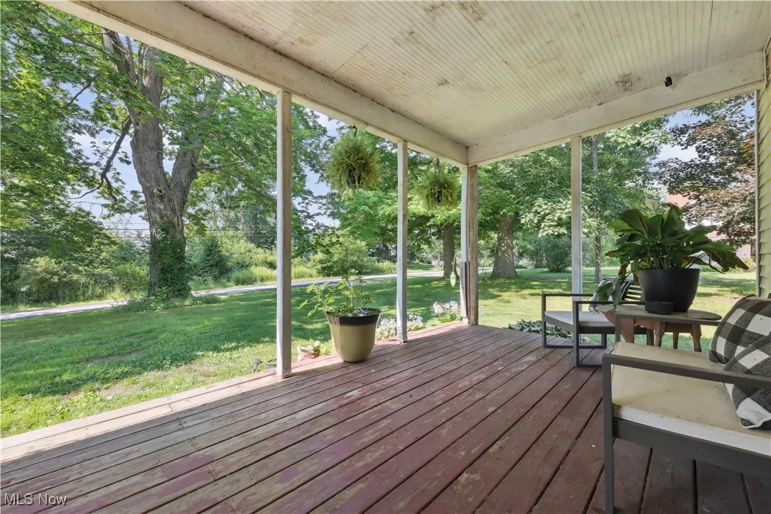 Wooden deck featuring a lawn and view of wooded area