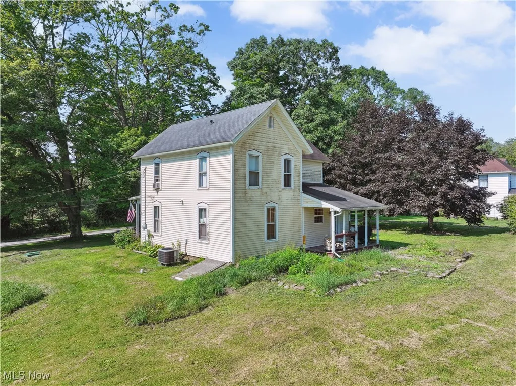 View of side of home featuring a yard