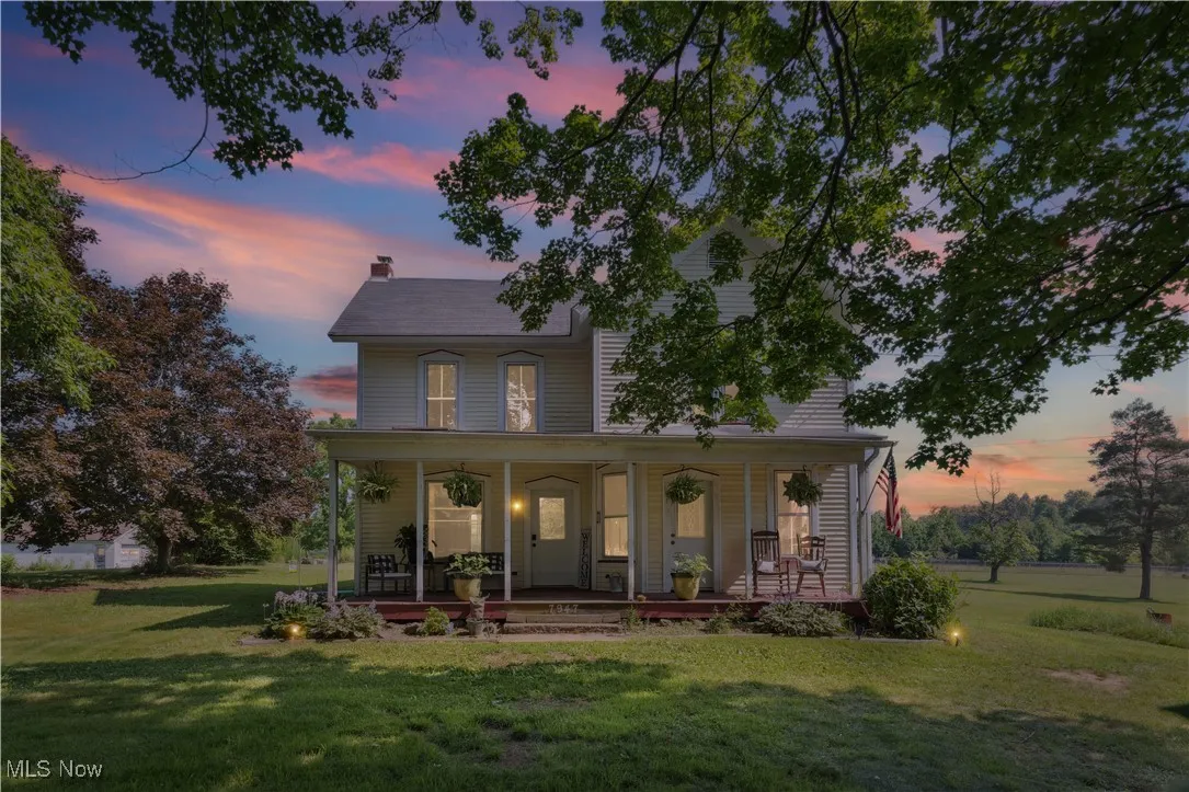 View of front facade featuring a porch, a front yard, and a chimney