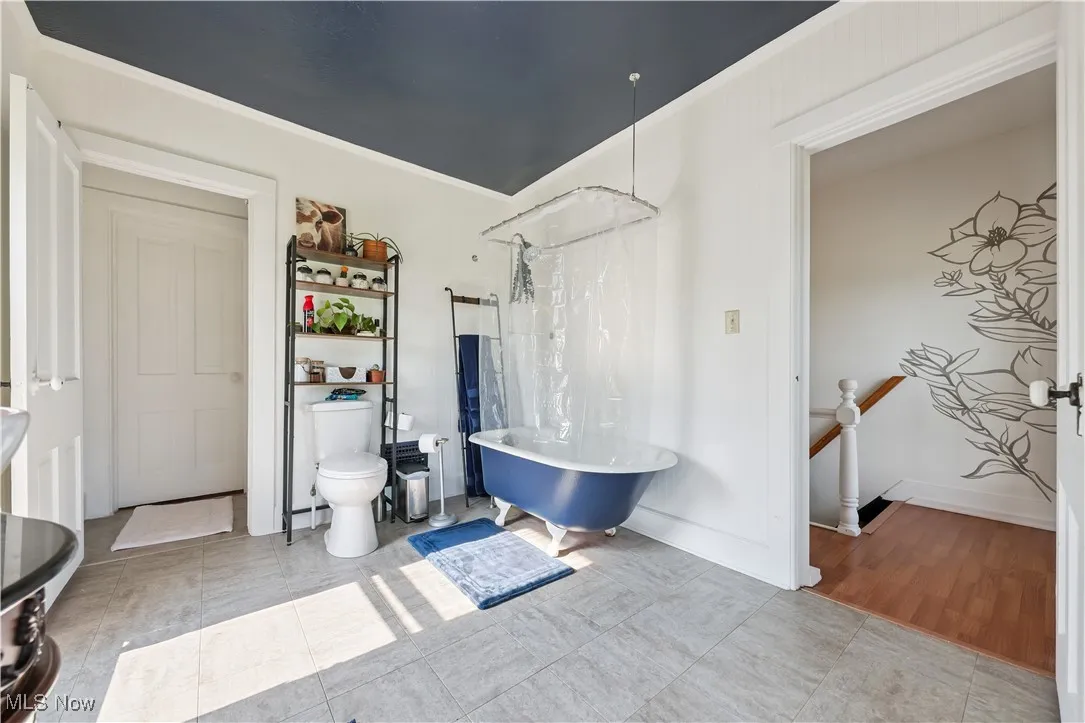 Bathroom with toilet and ornamental molding