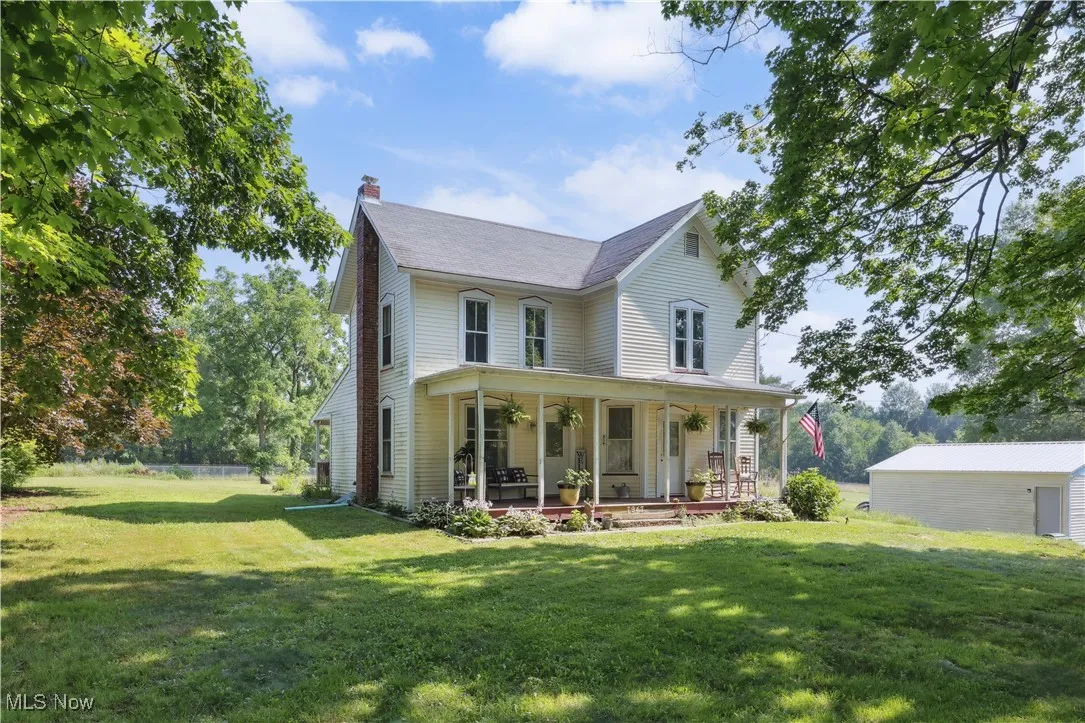 Victorian-style house featuring a front yard, a chimney, and a porch