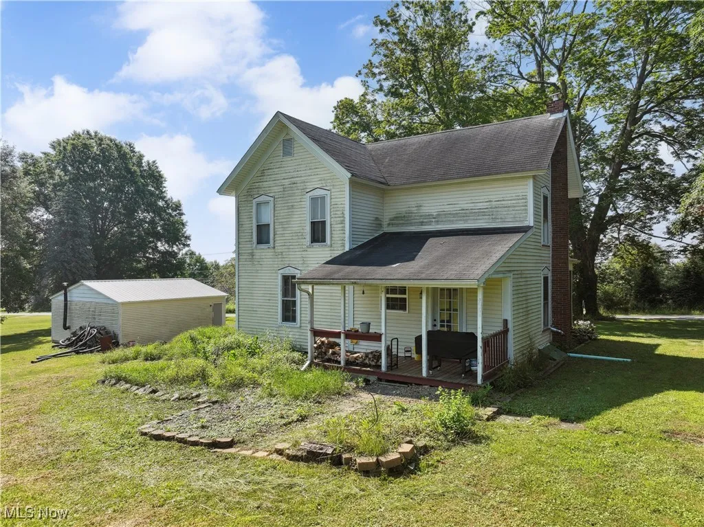 View of front of property featuring a front yard, a porch, and a chimney