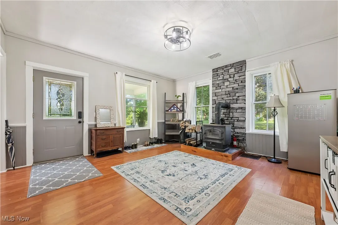 Foyer featuring a wood stove, plenty of natural light, and light wood-style floors