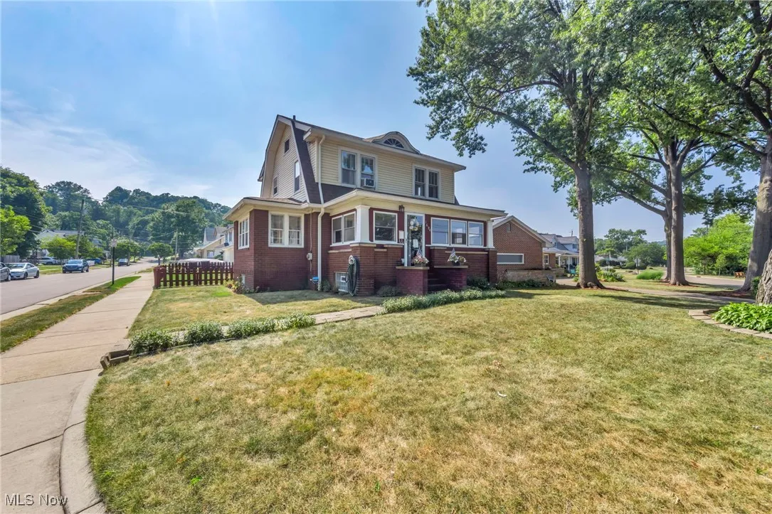 View of side of property featuring brick siding and a lawn