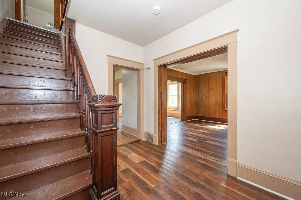 Stairway with wood finished floors and wood walls