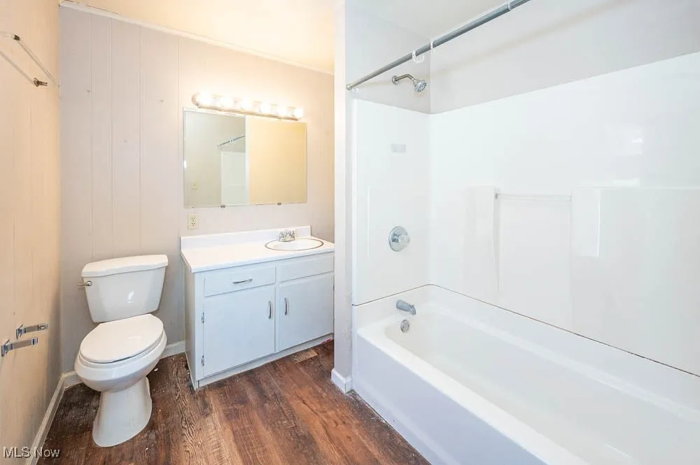 Full bathroom with wood finished floors, tub / shower combination, and vanity