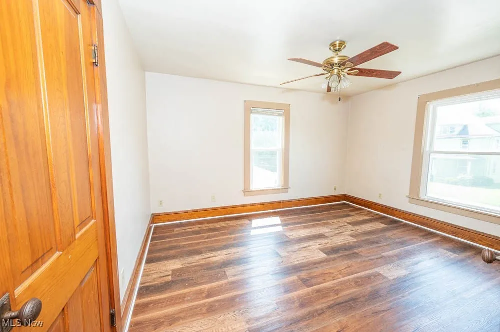 Spare room with wood finished floors and a ceiling fan