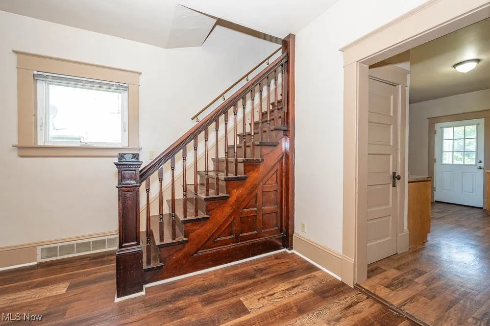 Stairs featuring wood finished floors