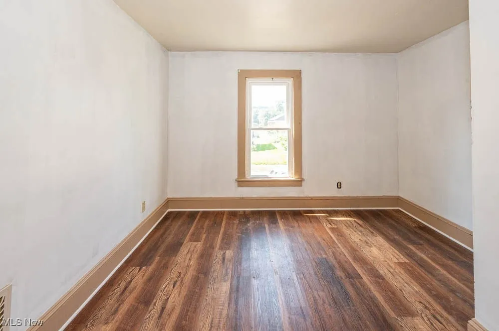 Empty room featuring wood finished floors and baseboards