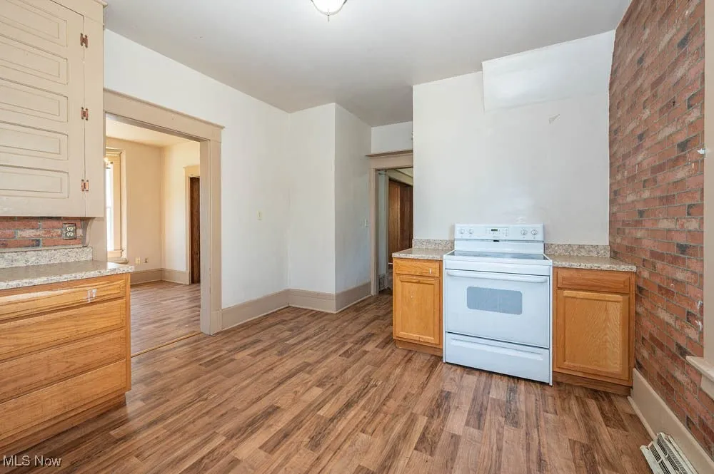 Kitchen featuring white electric range oven, light wood-type flooring, and light countertops
