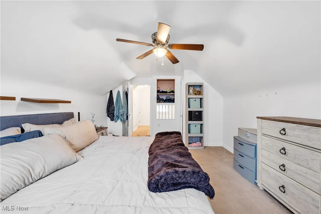 Bedroom featuring lofted ceiling, light colored carpet, and ceiling fan