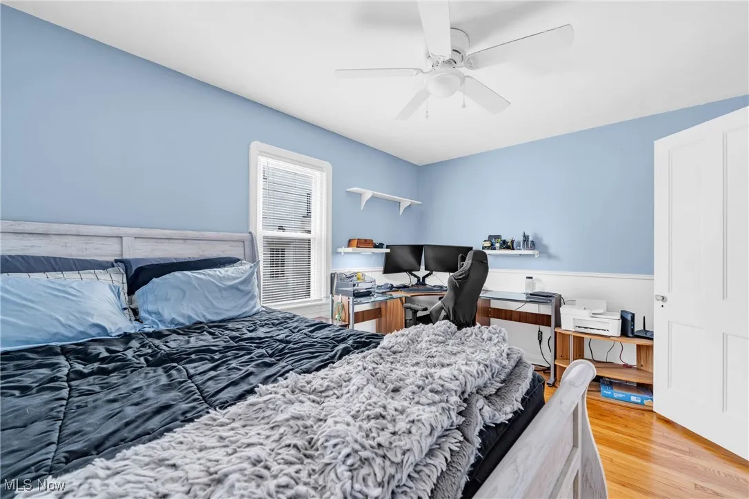 Bedroom featuring wood finished floors, ceiling fan, and a desk