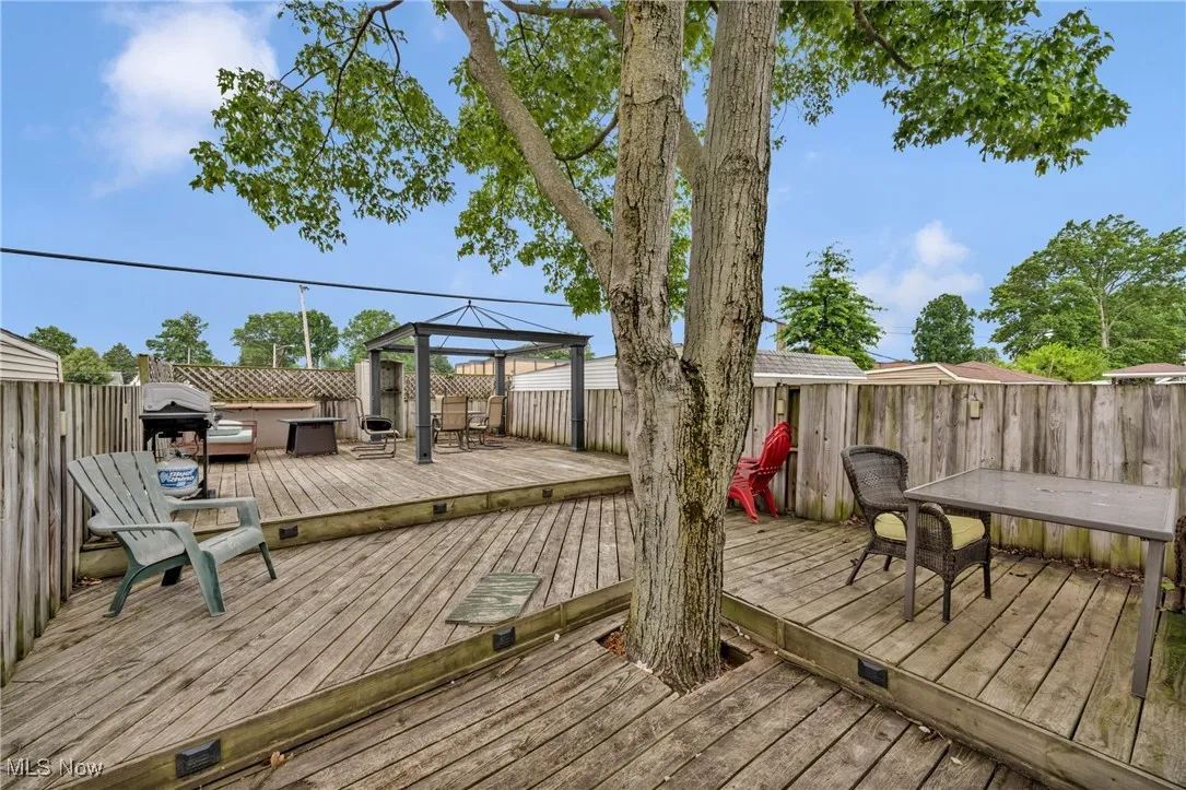 Deck featuring a gazebo, a fenced backyard, and outdoor dining space
