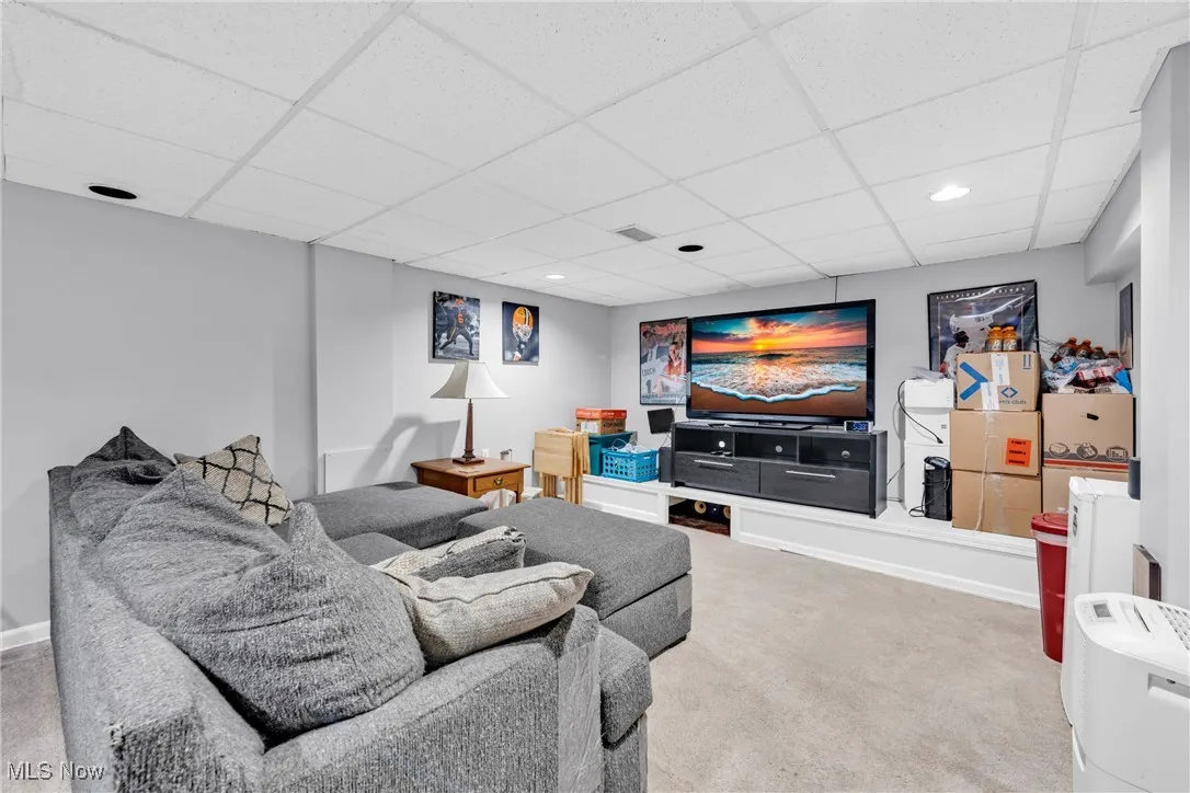 Carpeted living room featuring a drop ceiling and recessed lighting