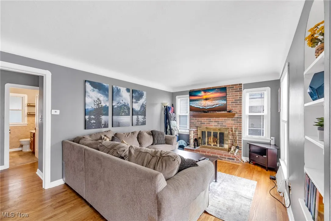 Living area featuring light wood finished floors and a brick fireplace