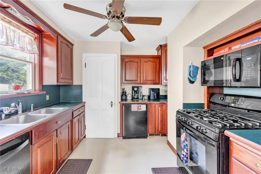 Kitchen with black appliances and a ceiling fan