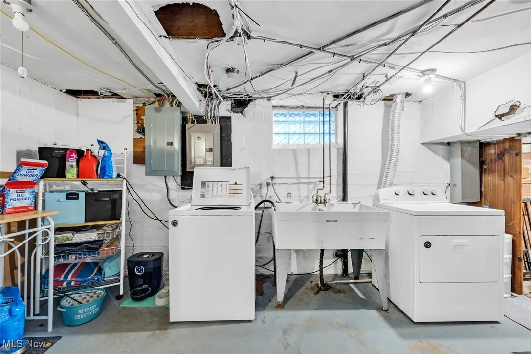 Washroom featuring washing machine and clothes dryer and electric panel