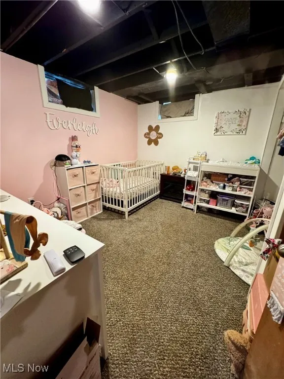 Carpeted bedroom featuring a nursery area