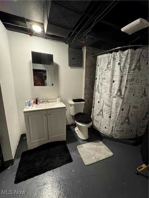 Bathroom with vanity, electric panel, curtained shower, and concrete floors