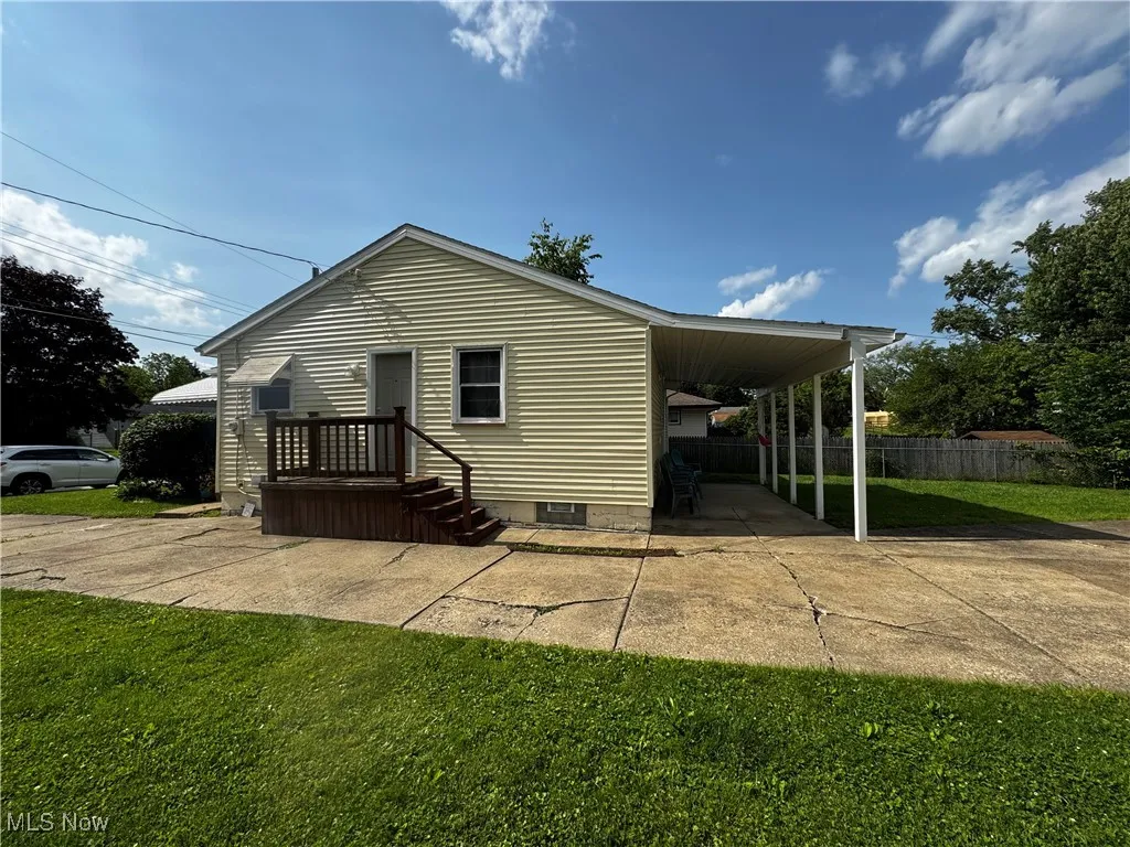 Back of house featuring driveway and an attached carport